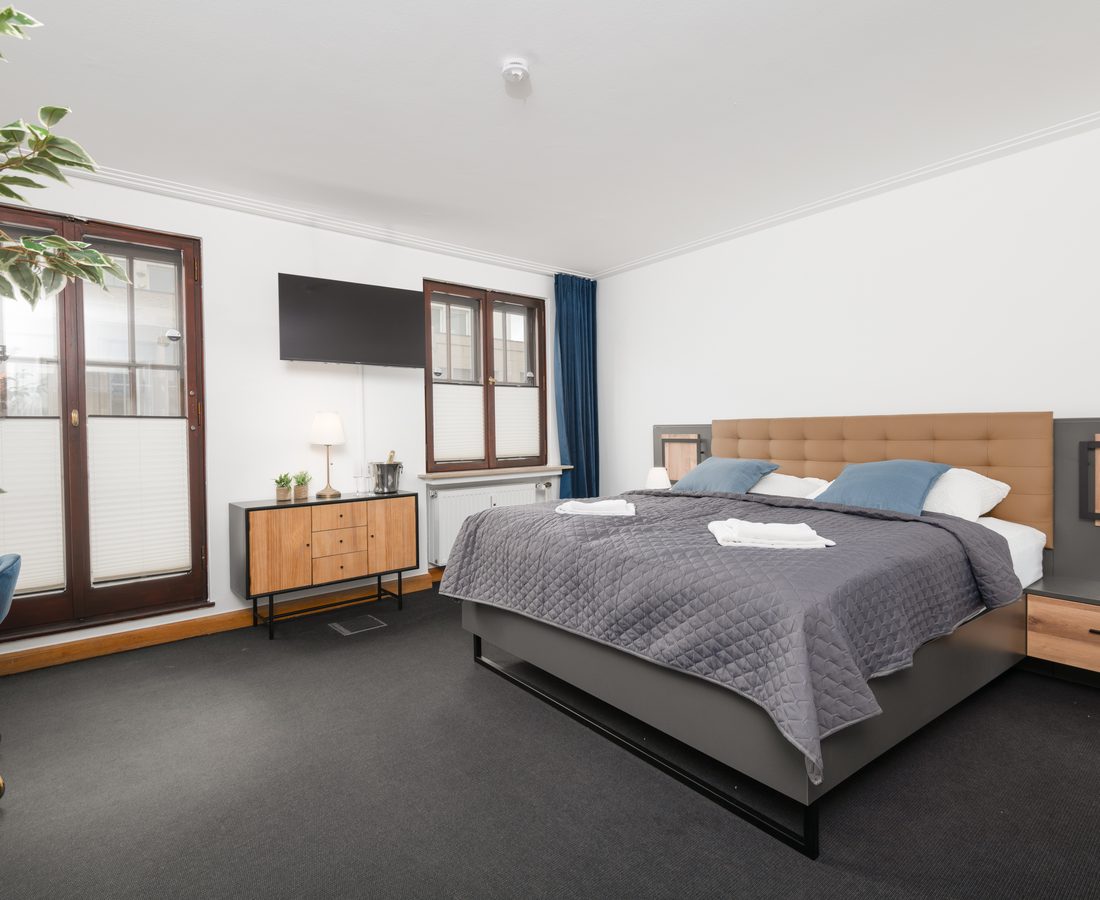 Schlafzimmer mit Doppelbett vor einem Fenster