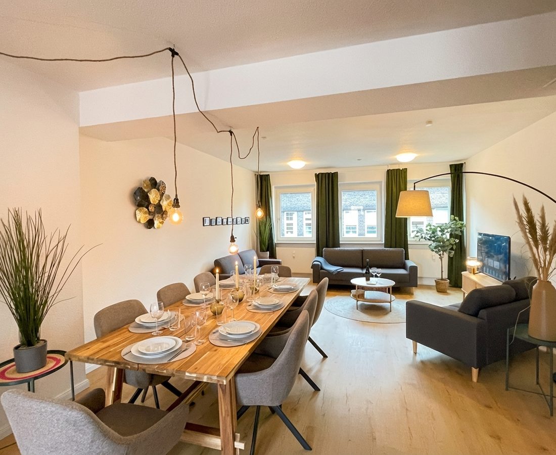 Wohn- und Essbereich mit langem Holztisch und Sitzgruppe